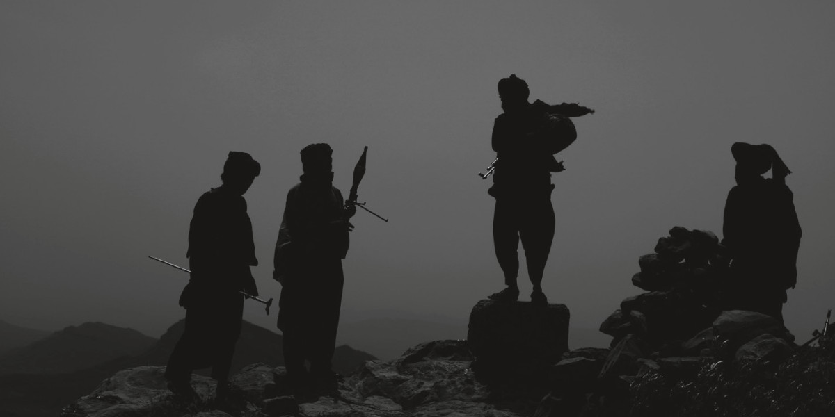 A black and white photo showing silhouetted militants holding weapons