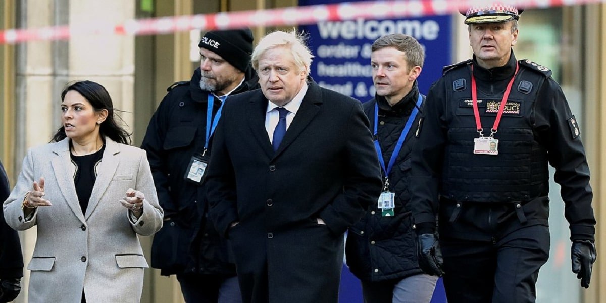 Boris Johnson and Priti Patel walking with police officers in London