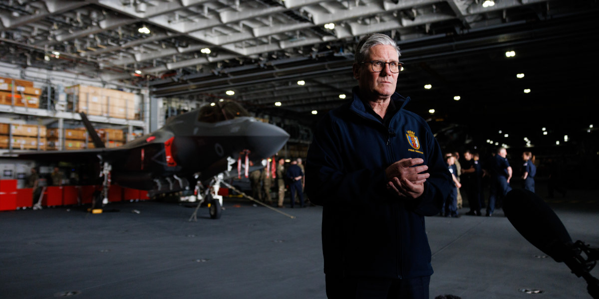 UK Prime Minister Keir Starmer in aboard the aircraft carrier HMS Prince of Wales, with a fighter jet in the background