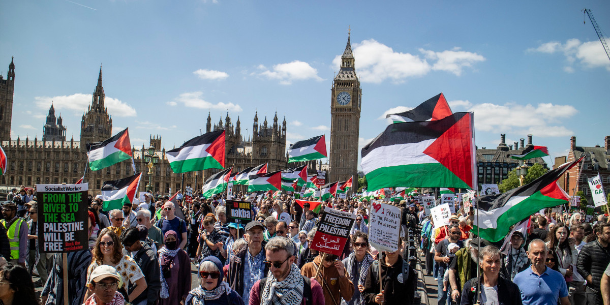 Thousands of protestors with Palestine flags march in front of Big Ben and the Houses of Parliament