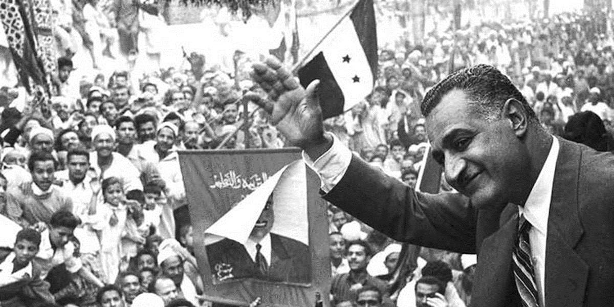 Black and white photo of Egyptian President Gamal Abdel Nasser waiving to a crowd in Mansoura, 1960