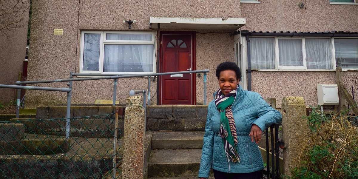 A woman in front of a concrete panel house