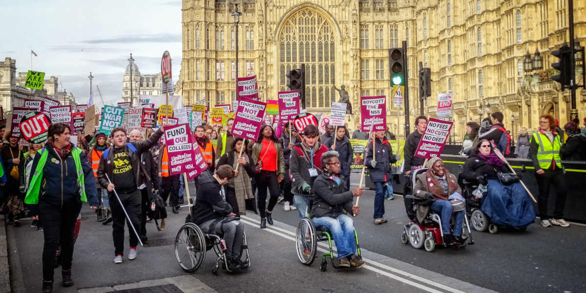 Protestors outside the Houses of Parliament, with wheelchair users in the forefront, at the United for Education march